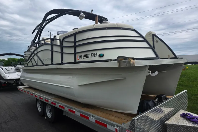 Slide: The Image of 2022 Lexington 621TT Extreme pontoon boat on trailer under cloudy sky. - 5
