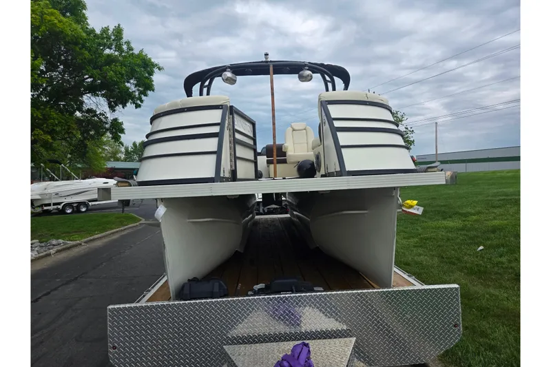Slide: The Image of 2022 Lexington 621TT Extreme pontoon boat on trailer, parked outdoors. - 6