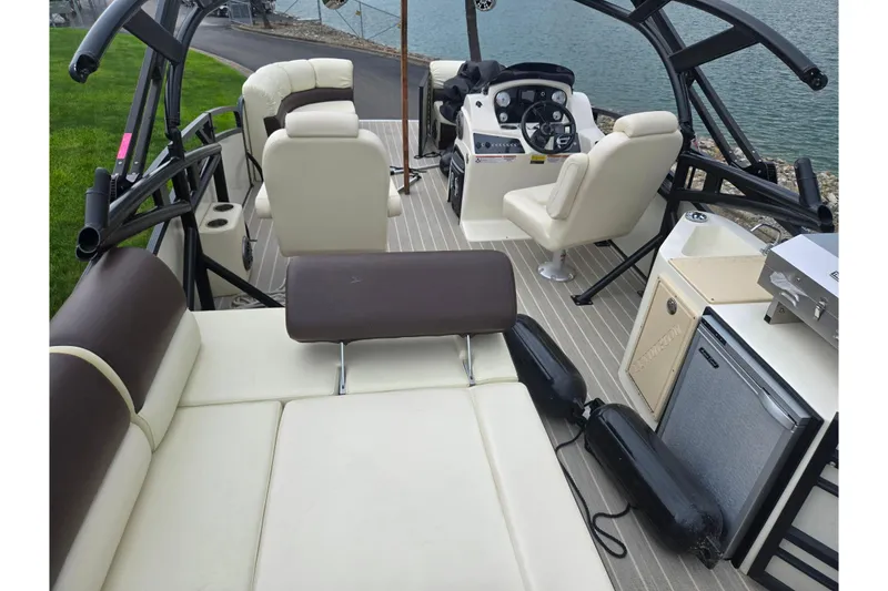 Slide: The Image of 2022 Lexington 621TT Extreme boat interior with seating, helm, and amenities by the water. - 9