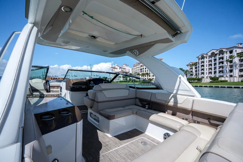 Slide: The Image of 2018 Formula 350 Crossover Bowrider OB interior with luxurious seating, docked near waterfront buildings. - 18