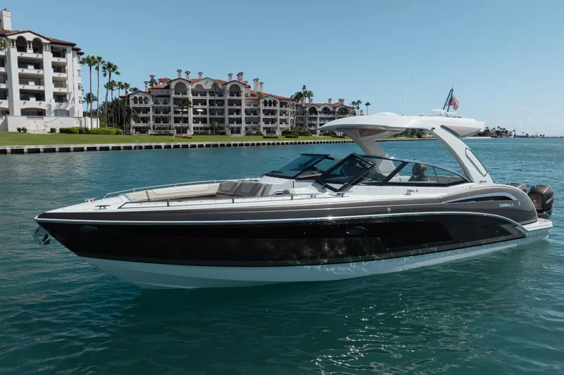 Slide: The Image of 2018 Formula 350 Crossover Bowrider OB cruising on a sunny waterfront near luxury apartments. - 4