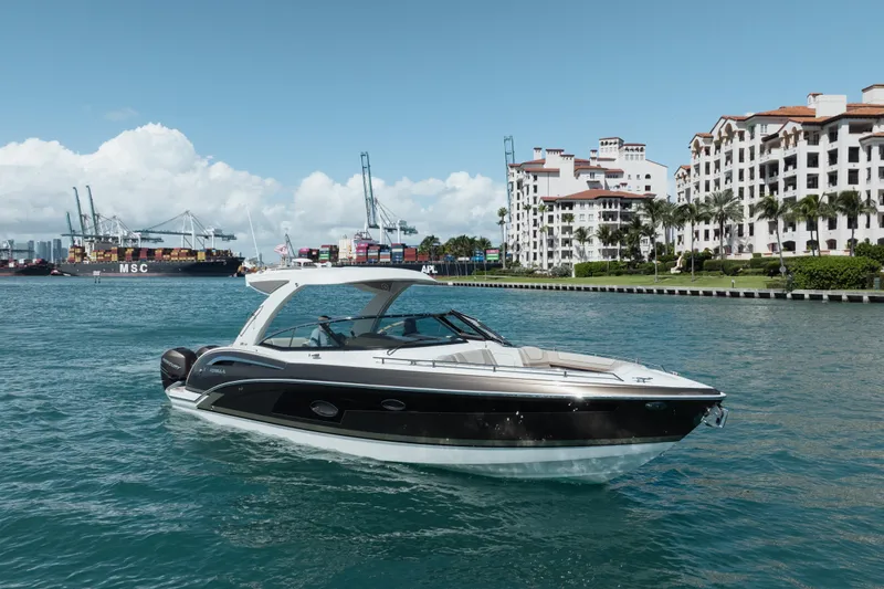 Slide: The Image of 2018 Formula 350 Crossover Bowrider OB cruising near waterfront buildings and cargo ships. - 5