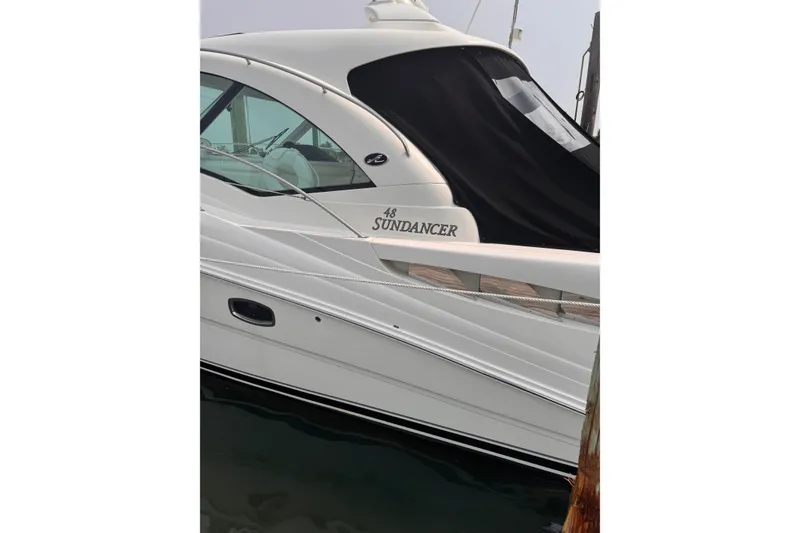 Slide: The Image of 2007 Sea Ray 48 Sundancer yacht docked, showcasing sleek design and elegant curves. - 5