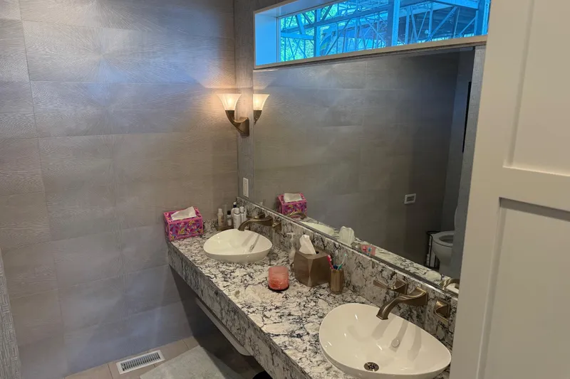 Slide: The Image of Modern bathroom with dual sinks, granite countertop, and elegant lighting fixtures. - 11