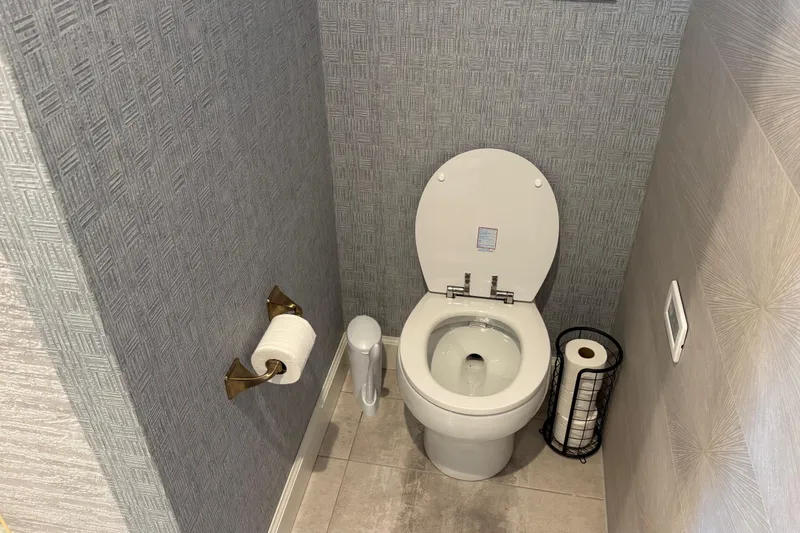 Slide: The Image of Modern bathroom with a white toilet, textured wallpaper, and toilet paper holder. - 12