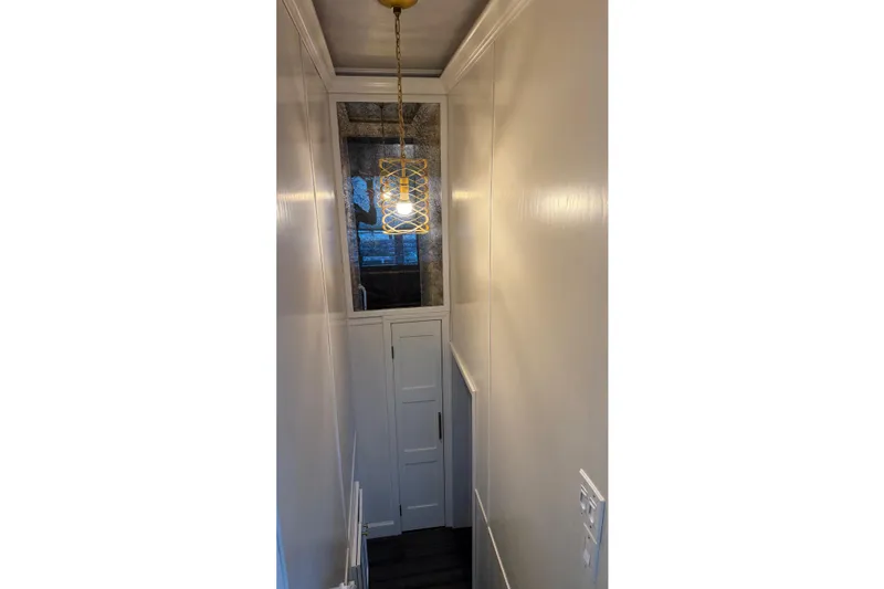Slide: The Image of Narrow hallway with modern pendant light and white paneled walls, Thoroughbred 20 x 102 model. - 14