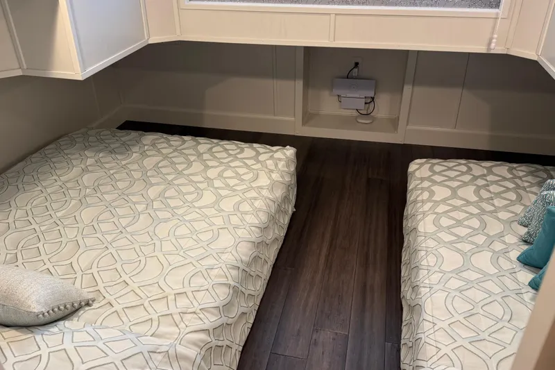 Slide: The Image of Interior of 2020 Thoroughbred 20 x 102 trailer with twin beds and patterned bedding. - 15
