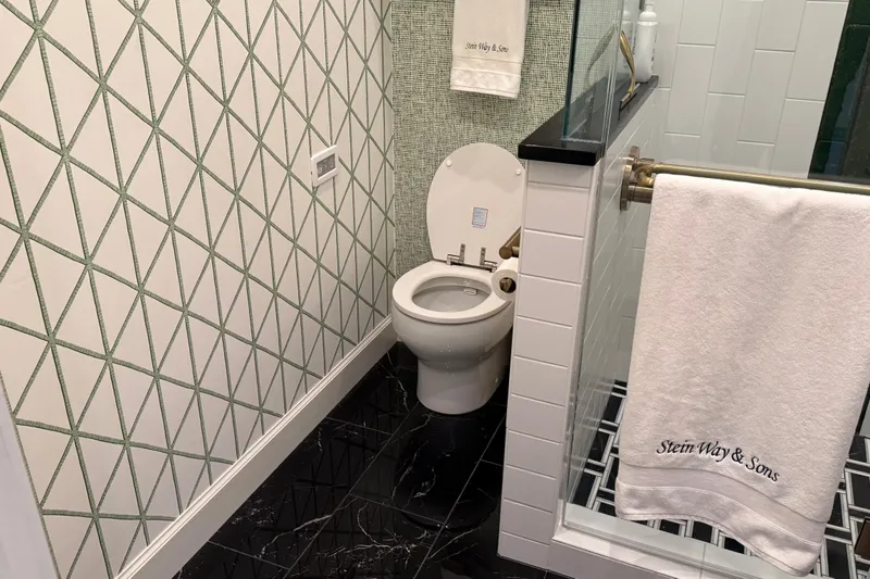 Slide: The Image of Modern bathroom with geometric wallpaper, black marble floor, and white fixtures. - 21