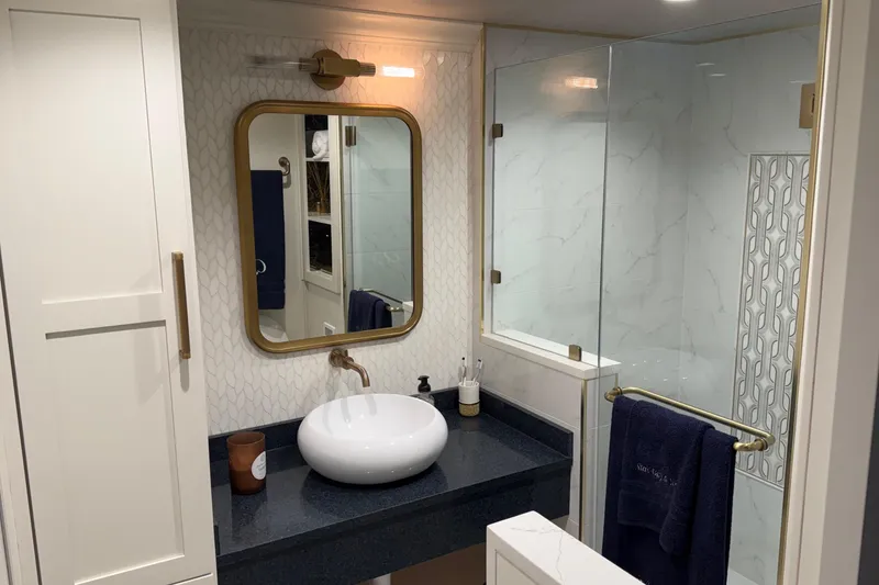 Slide: The Image of Modern bathroom with glass shower, vessel sink, and gold-framed mirror in a 2020 Thoroughbred model. - 22
