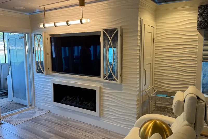 Slide: The Image of Luxurious 2020 Thoroughbred interior with modern TV, fireplace, and elegant wave-patterned walls. - 42