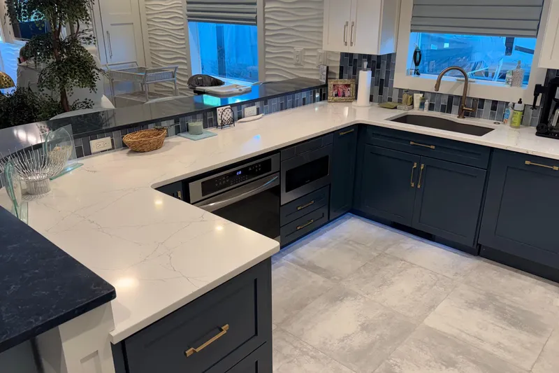 Slide: The Image of Modern kitchen with navy cabinets, marble countertops, and stainless steel appliances, Thoroughbred 20 x 102 model. - 47