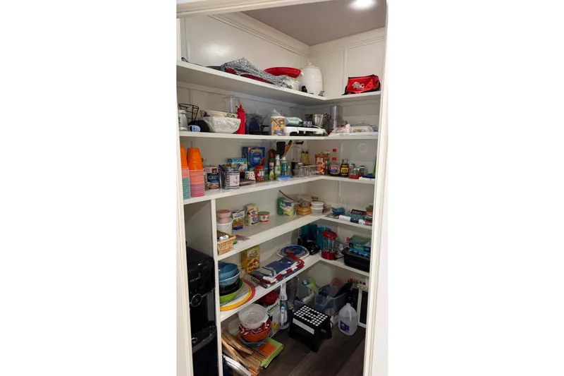 Slide: The Image of Organized pantry with shelves stocked with food, kitchenware, and appliances in a Thoroughbred 20 x 102 RV. - 51