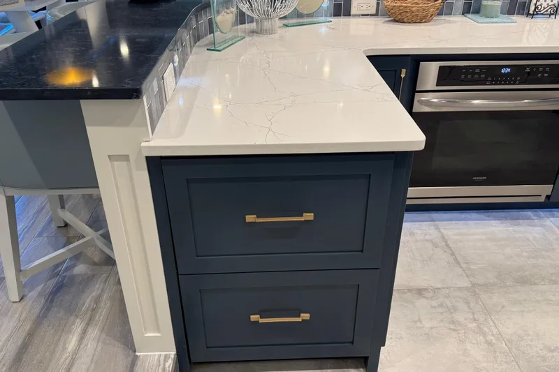 Slide: The Image of Modern kitchen with navy cabinets, marble countertop, and stainless steel appliances, Thoroughbred 20 x 102 model. - 53