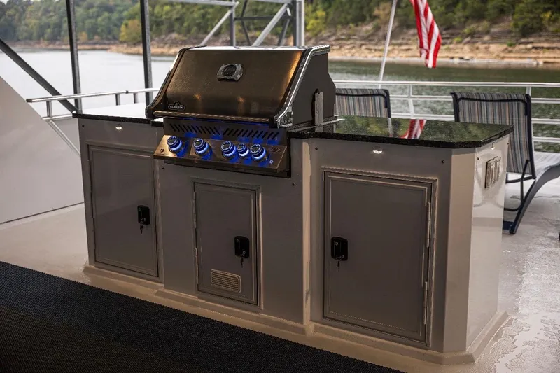 Slide: The Image of Outdoor grill setup on a Thoroughbred 20 x 102 boat, 2020 model, with scenic lake view. - 55