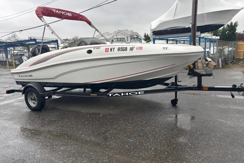 The Image of 2022 Tahoe T16 boat on trailer, parked outdoors on a rainy day. - 0