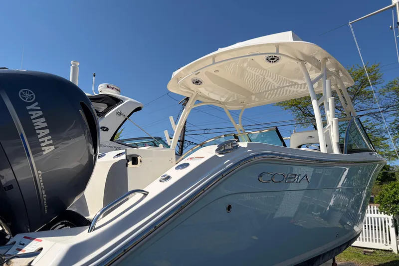 The Image of 2022 Cobia 280 Dual Console boat with Yamaha engine, docked under clear blue sky. - 0