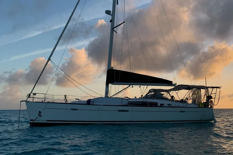 The Image of 2007 Beneteau 49 sailboat on calm ocean at sunset, silhouetted against colorful sky. - 0