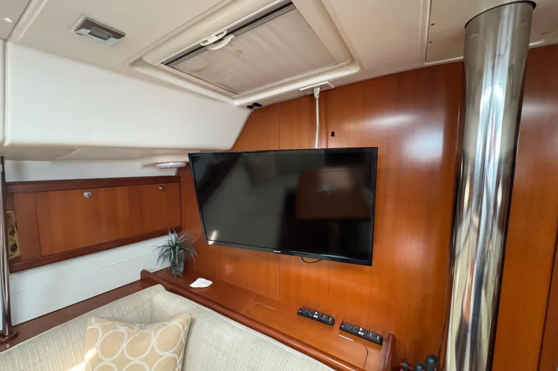 Slide: The Image of Interior of 2007 Beneteau Oceanis 49 yacht with TV, wood paneling, and cozy seating. - 10