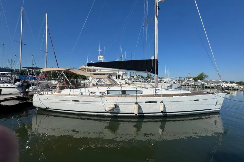 Slide: The Image of 2007 Beneteau Oceanis 49 sailboat docked in a marina under clear blue skies. - 2