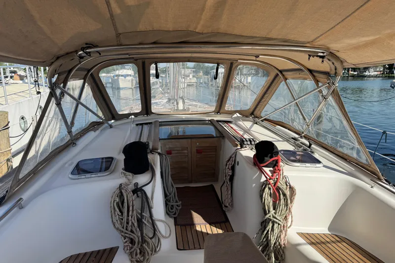 Slide: The Image of 2007 Beneteau Oceanis 49 sailboat cockpit with ropes and canopy, docked by the water. - 31