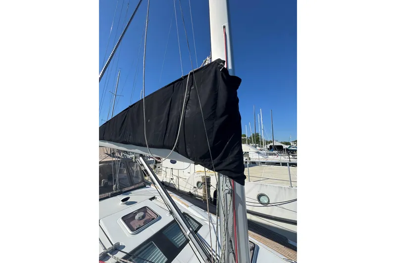 Slide: The Image of 2007 Beneteau Oceanis 49 sailboat mast and boom with black sail cover in marina. - 37