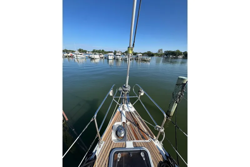 Slide: The Image of Bow view of 2007 Beneteau Oceanis 49 sailboat docked in a serene marina. - 46