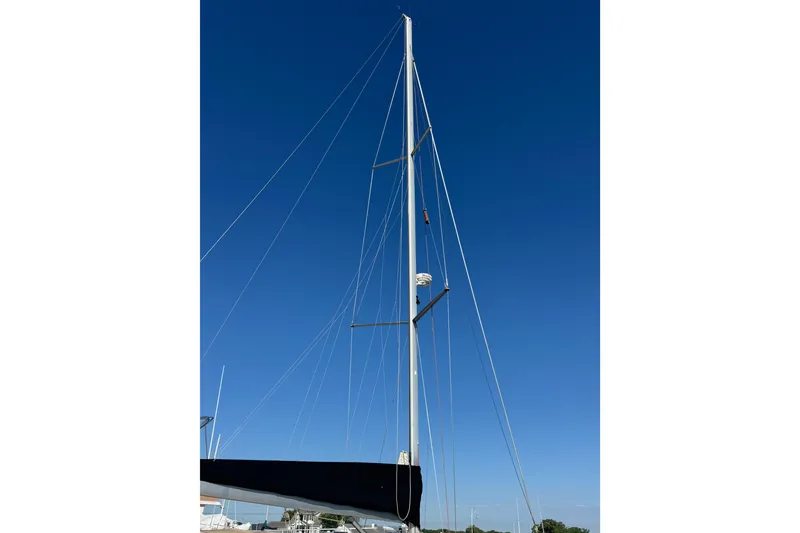 Slide: The Image of Tall mast of a 2007 Beneteau Oceanis 49 sailboat against a clear blue sky. - 50