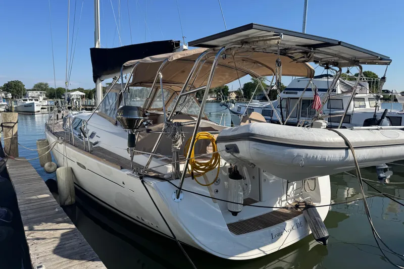 Slide: The Image of 2007 Beneteau Oceanis 49 sailboat docked at a marina with inflatable dinghy. - 53
