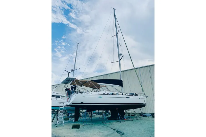 Slide: The Image of 2007 Beneteau 49 sailboat on stands, with a clear sky background. - 54