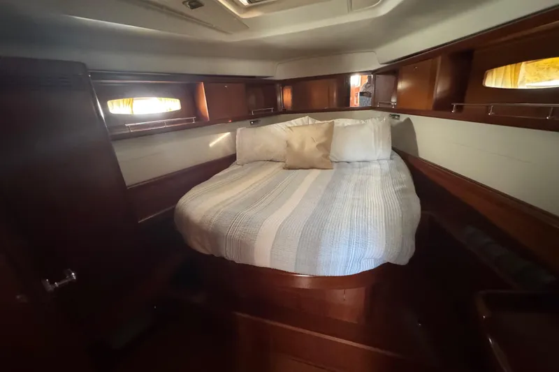 Slide: The Image of Cozy cabin interior of 2007 Beneteau Oceanis 49 sailboat with striped bedding and wooden finish. - 9