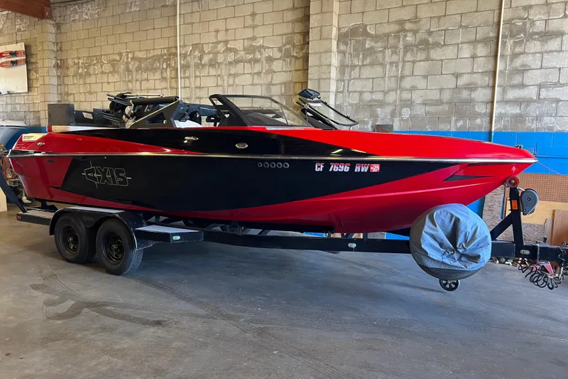 Slide: The Image of 2016 Axis T22 boat in red and black on a trailer in a garage. - 21