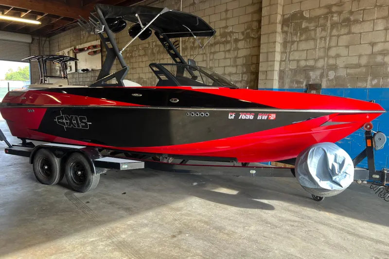 Slide: The Image of Red and black 2016 Axis T22 boat on trailer in a garage setting. - 23
