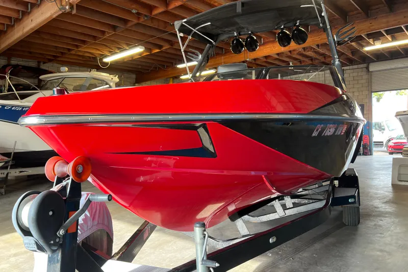 Slide: The Image of Red 2016 Axis T22 boat on trailer in a garage setting. - 26