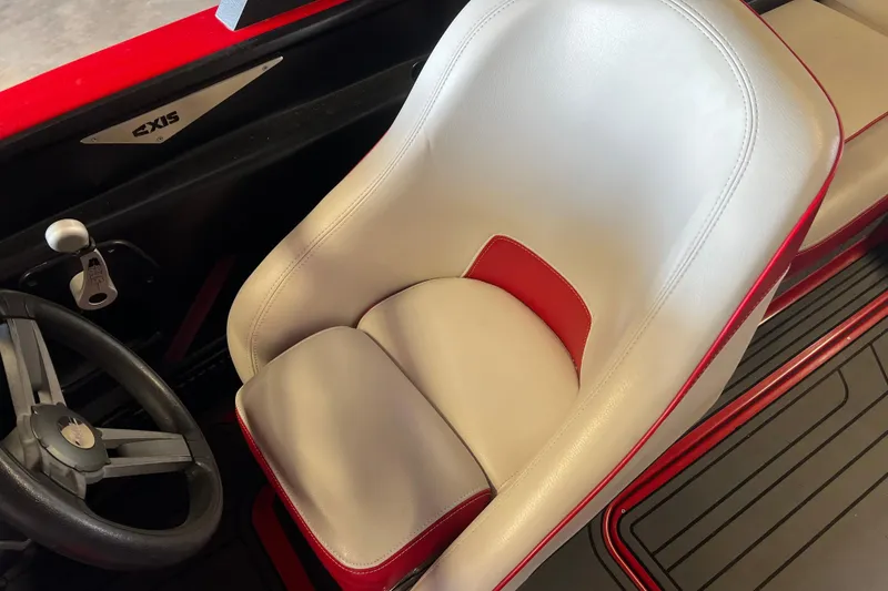 Slide: The Image of 2016 Axis T22 boat interior with white and red captain's seat and steering wheel. - 30