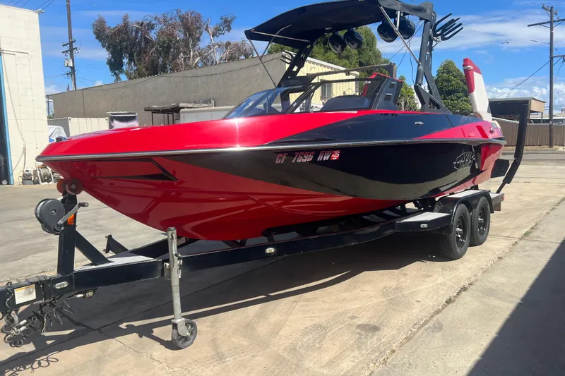 Slide: The Image of Red and black 2016 Axis T22 boat on trailer in industrial area. - 36