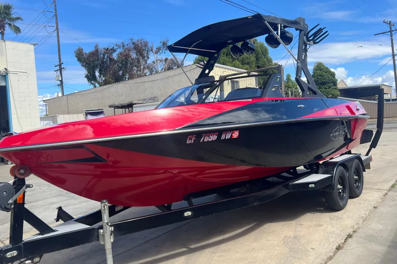 Slide: The Image of 2016 Axis T22 boat in red and black on a trailer, parked outdoors. - 6