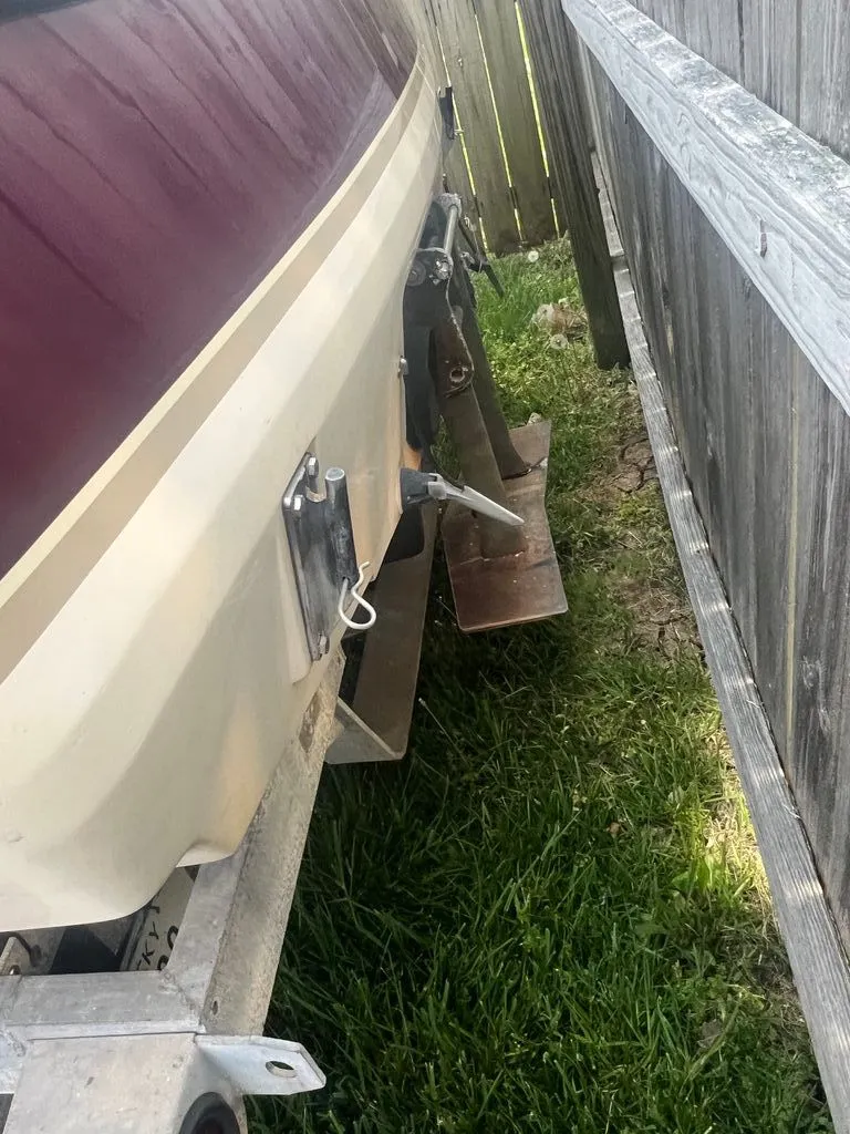 Slide: The Image of Rear view of a 1997 Malibu Sunsetter LX boat beside a wooden fence. - 6