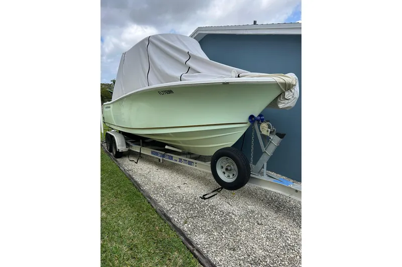 Slide: The Image of 2018 Sportsman Heritage 231 Center Console boat on trailer, covered and parked outdoors. - 3