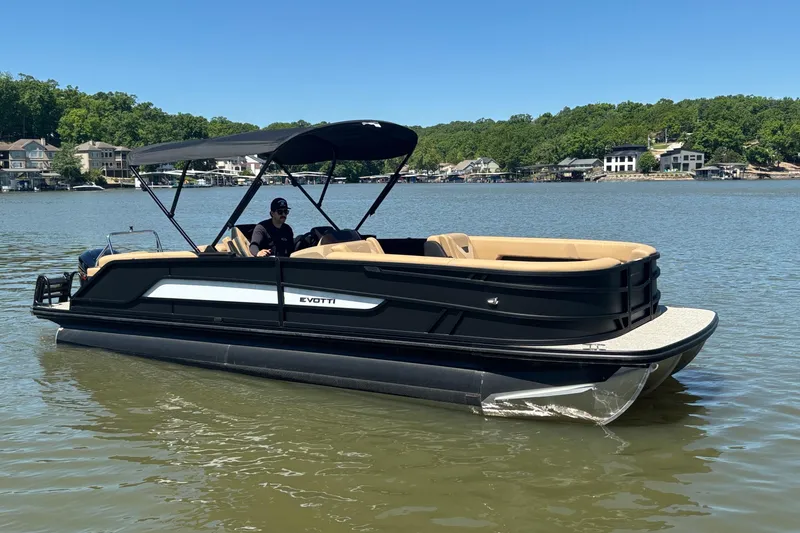 The Image of 2026 Evotti 525QL pontoon boat on a serene lake with lush green shoreline. - 1