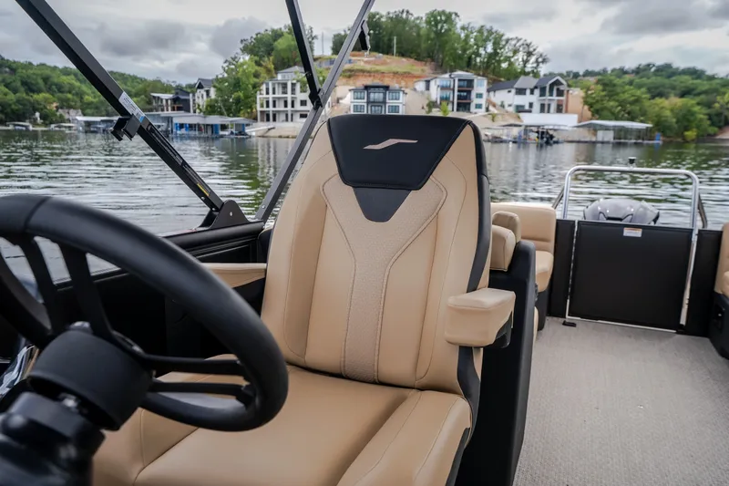 Slide: The Image of Luxury interior of 2026 Evotti 525QL boat with beige seating, steering wheel, and scenic lake view. - 31