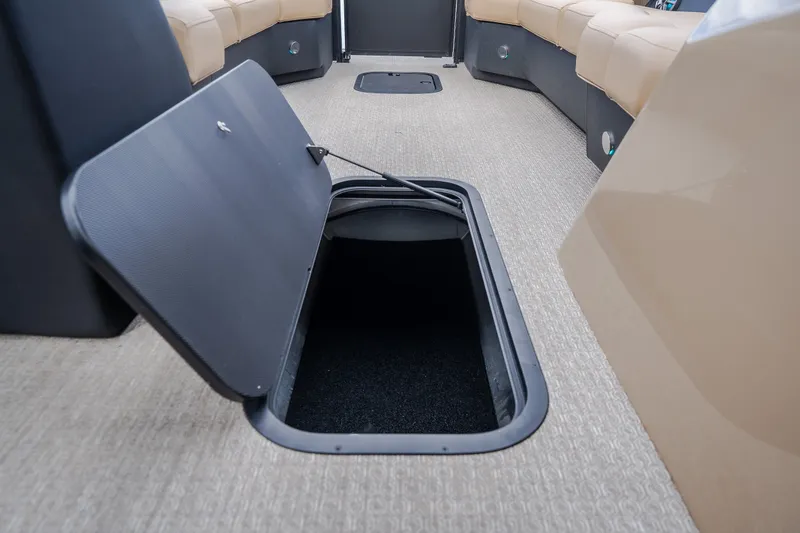 Slide: The Image of Open storage compartment in 2026 Evotti 525QL boat interior, featuring beige seating and carpeted flooring. - 27