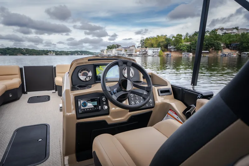 Slide: The Image of Interior view of 2026 Evotti 525QL boat, featuring steering wheel and dashboard on a scenic lake. - 32