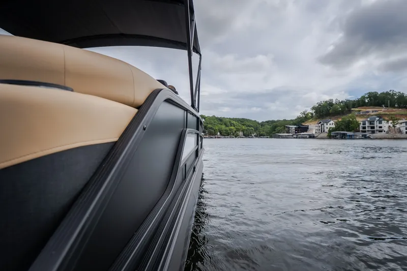 Slide: The Image of Evotti 525QL 2026 boat cruising on a scenic lake with shoreline view. - 59