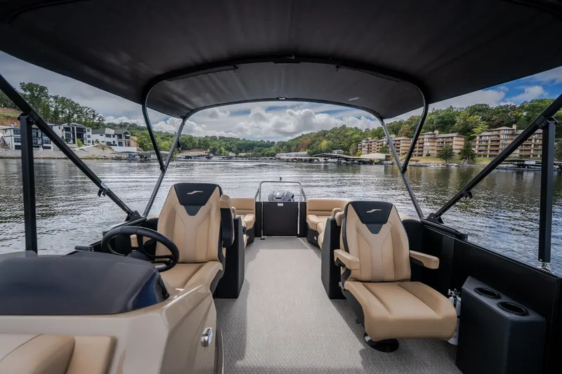 Slide: The Image of 2026 Evotti 525QL boat interior with tan seats, on a scenic lake. - 30
