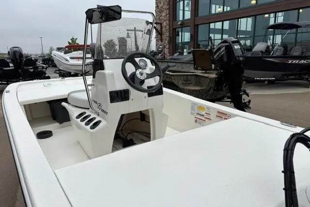 Slide: The Image of 2025 Mako Pro Skiff 13 CC boat with steering console, displayed outdoors. - 7