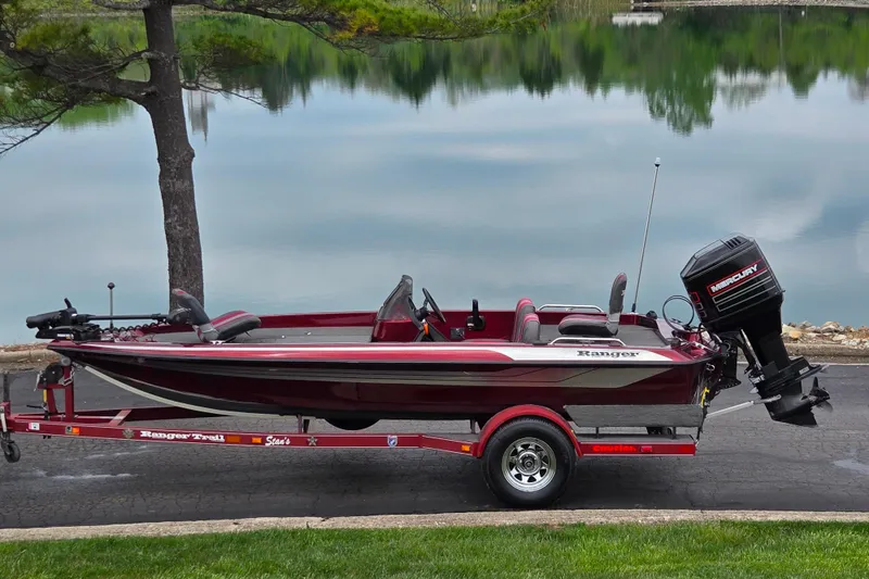 The Image of 1995 Ranger R72 Sport boat on trailer by a serene lake. - 0