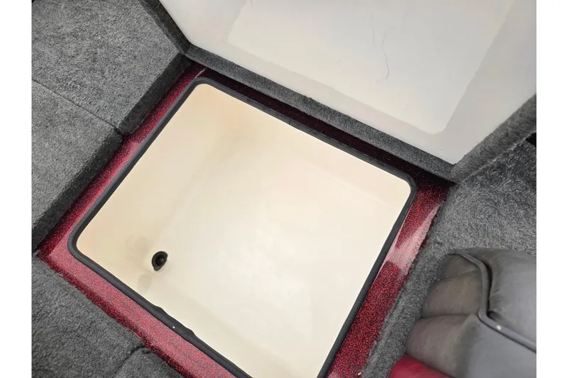 Slide: The Image of 1995 Ranger R72 Sport boat storage compartment with red trim and gray carpet. - 25