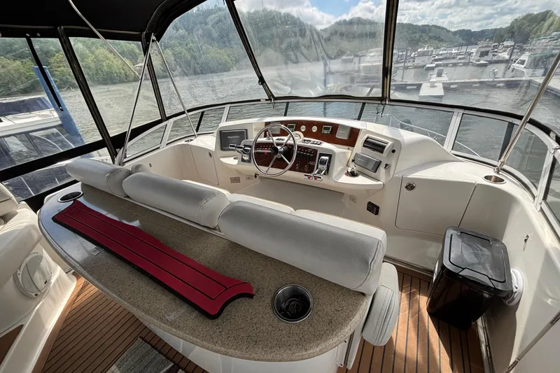 Slide: The Image of 2007 Silverton 43 Motor Yacht helm with panoramic marina view, featuring modern controls and seating. - 10