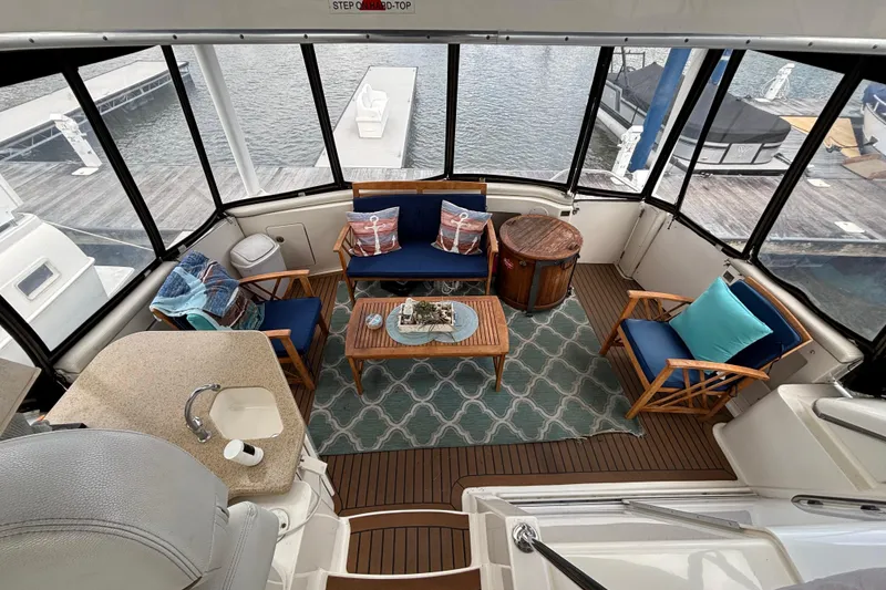 Slide: The Image of Luxurious 2007 Silverton 43 Motor Yacht interior with elegant seating and scenic marina view. - 5