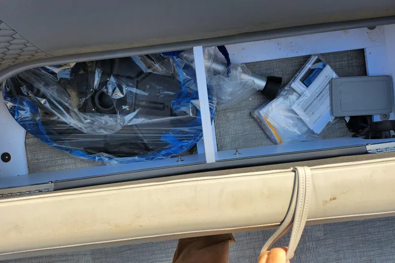 Slide: The Image of Storage compartment of 2024 Qwest Angler Qwest XRE boat with equipment and documents. - 12